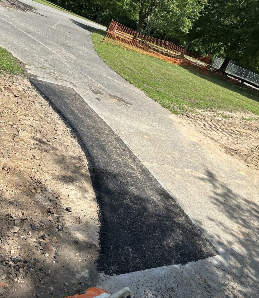 a trail with a patch of asphalt that has been replaced